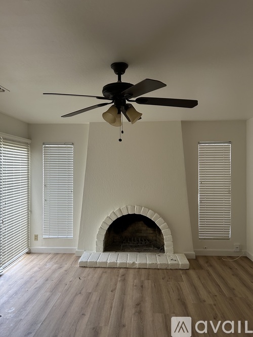 A room with a fireplace and a ceiling fan.