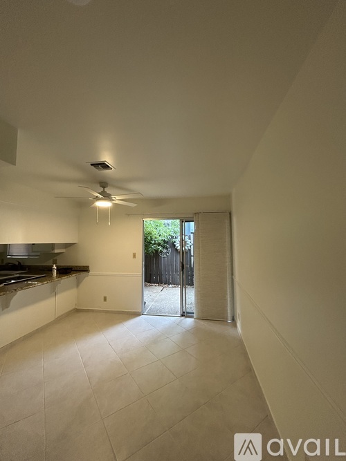 A spacious kitchen with a fan and a door leading outside.