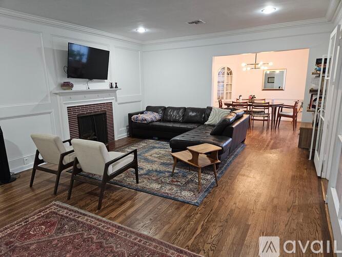 A living room with a fireplace and a television on the wall.