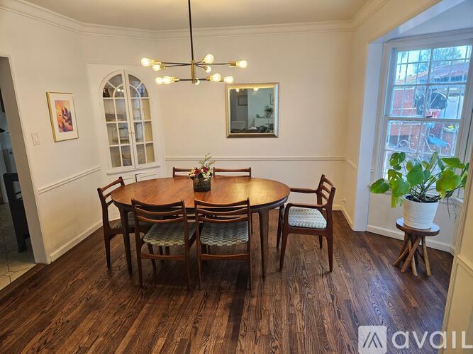 A dining room with a round table and chairs.