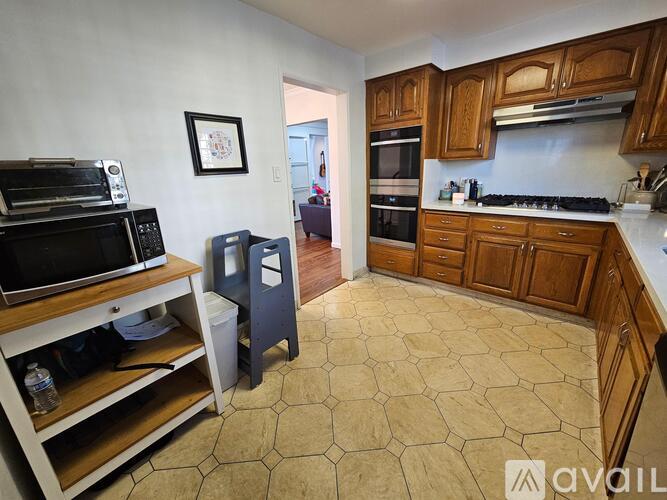 A kitchen with wooden cabinets and a tiled floor.