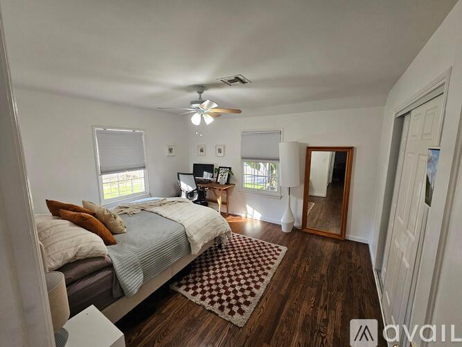 A bedroom with a bed, a ceiling fan, and a rug.