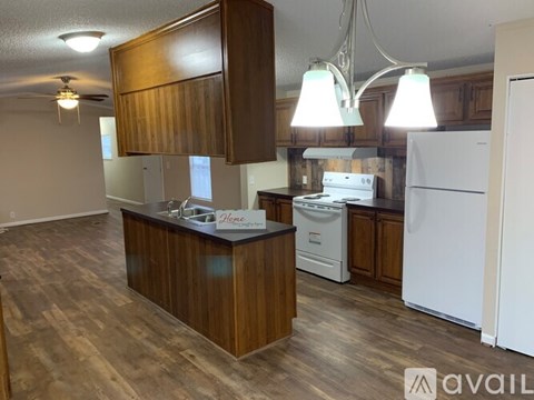 A kitchen with a white refrigerator and wooden cabinets.