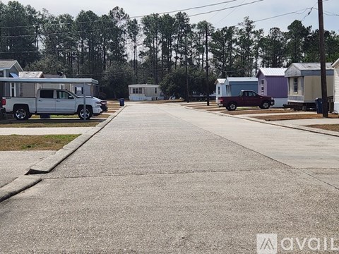 A street view of a residential area with houses and parked cars.