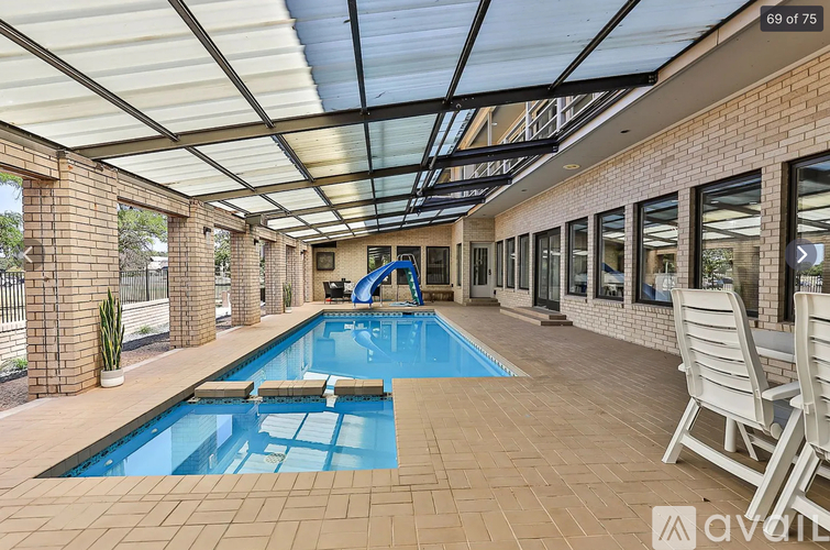 A pool area with a slide and lounge chairs.