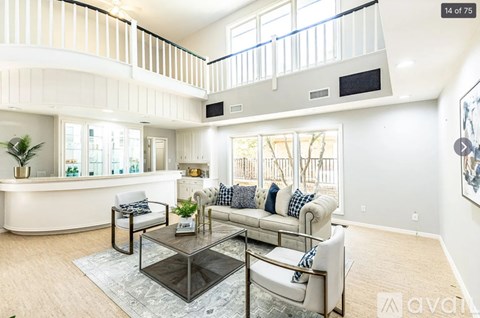 A living room with a white couch and a glass coffee table.