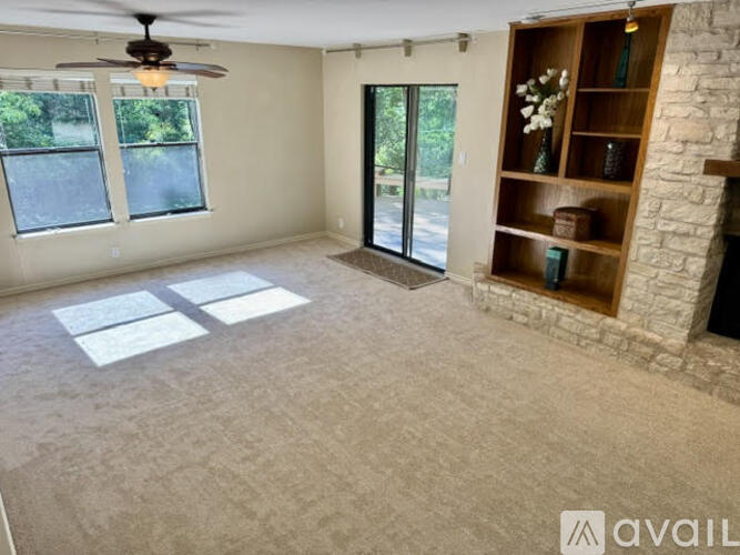 A living room with a fireplace and a fan on the ceiling.