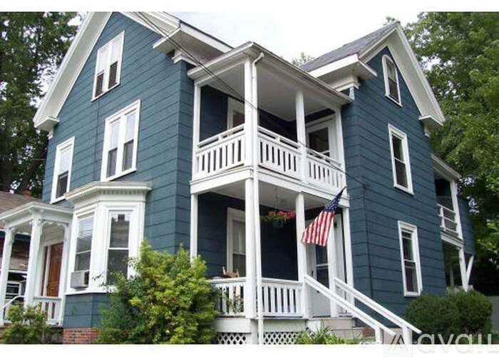 A blue house with a flag on the porch.