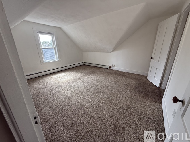 A room with a carpeted floor and a window.