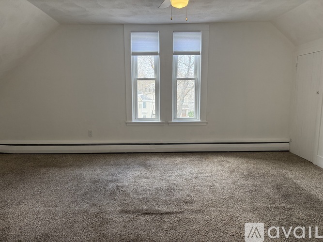 A room with a carpeted floor and a window.