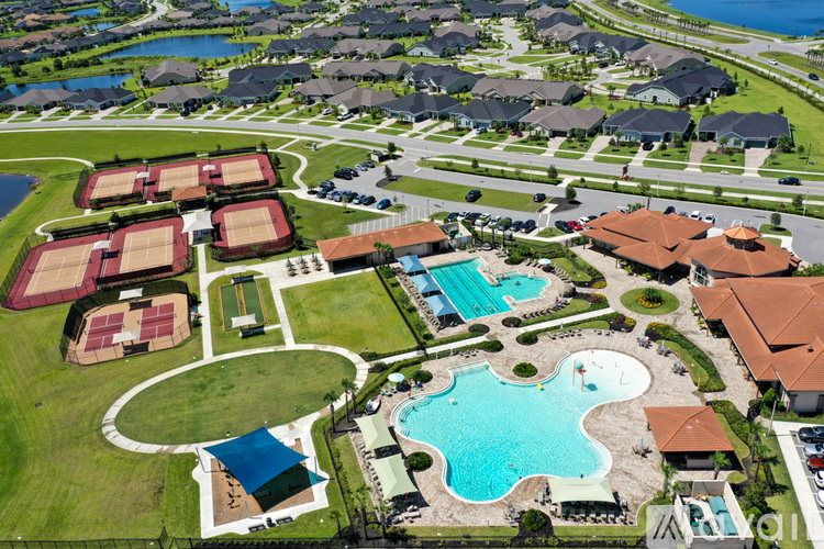 A bird's eye view of a residential area with a swimming pool and tennis courts.
