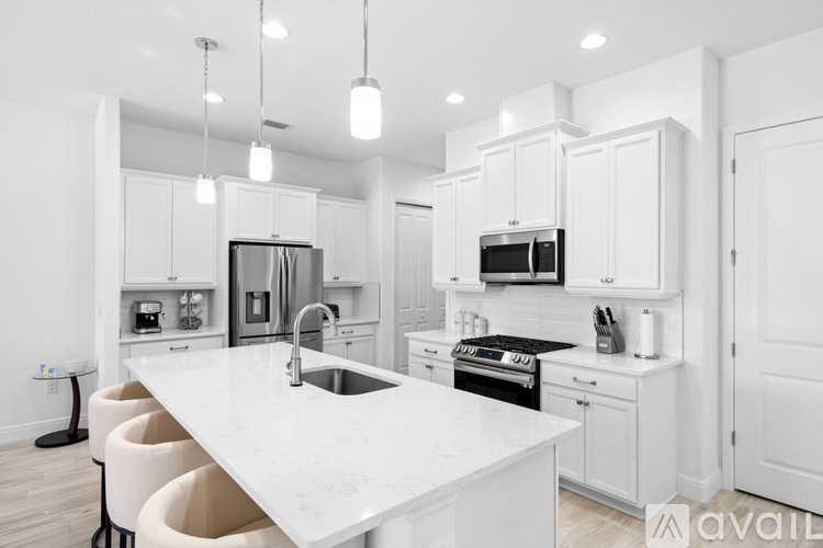 A modern kitchen with white cabinets and appliances.