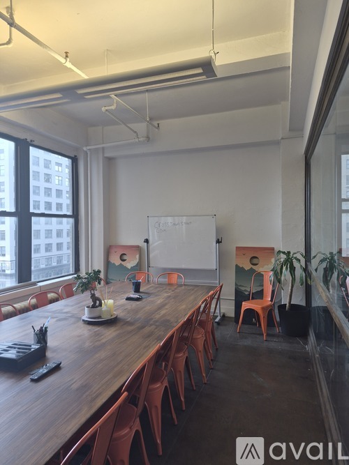 A conference room with a long table and chairs.