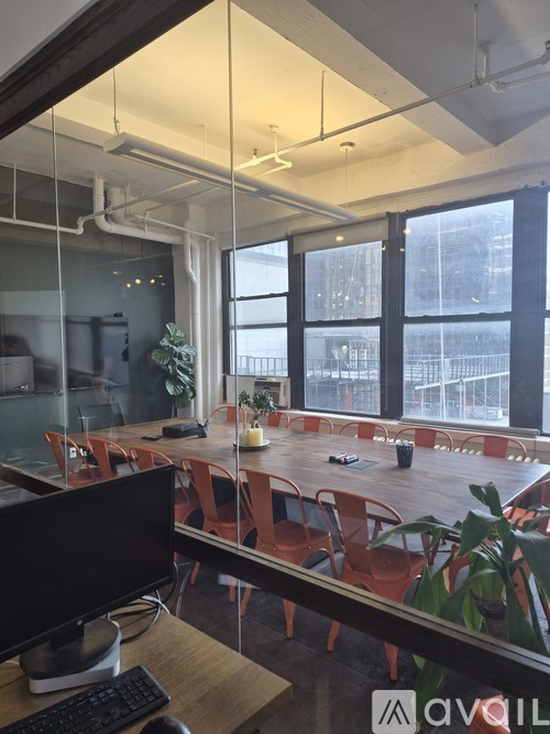 A modern office space with a glass wall and a view of the city.