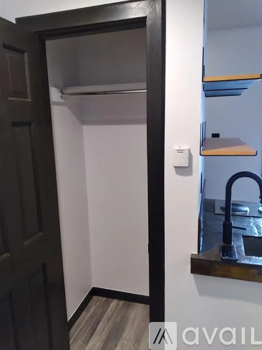 A small kitchen with a sink and a door leading to another room.