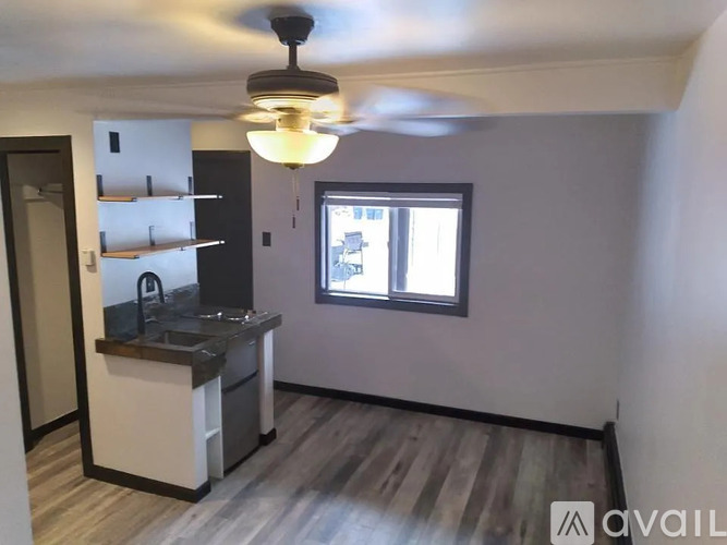 A kitchen with a window and a ceiling fan.