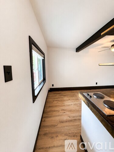 A kitchen with a window and a ceiling fan.