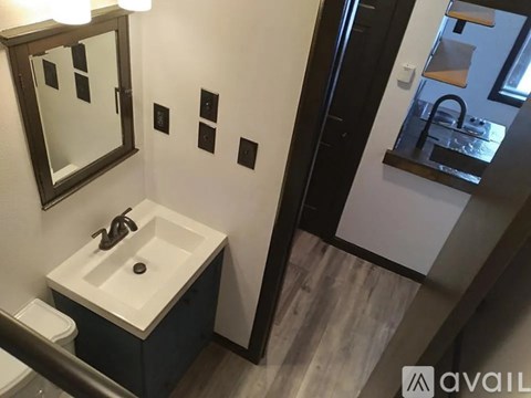 A bathroom with a white sink and a mirror.