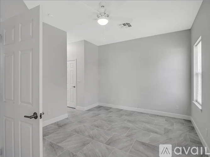 A room with a door on the left and a window on the right.