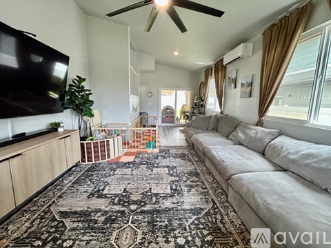 A living room with a large rug and a long white sofa.