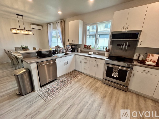A modern kitchen with white cabinets and stainless steel appliances.