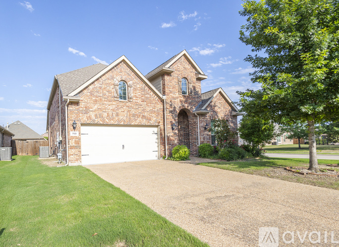 A house with a garage and a driveway in front of it.