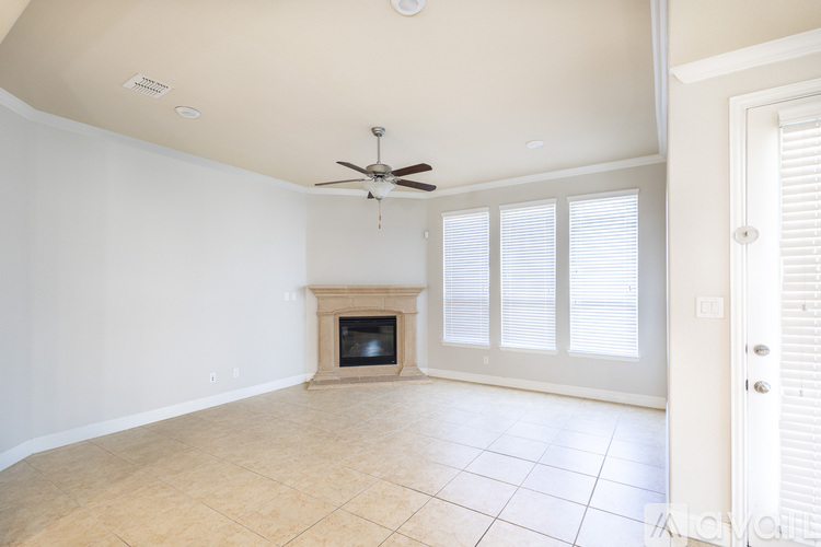 A living room with a fireplace and a ceiling fan.