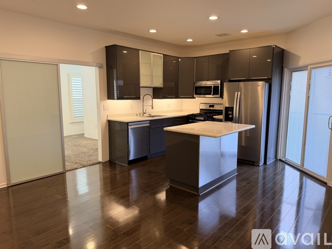 A modern kitchen with dark wood cabinets and stainless steel appliances.