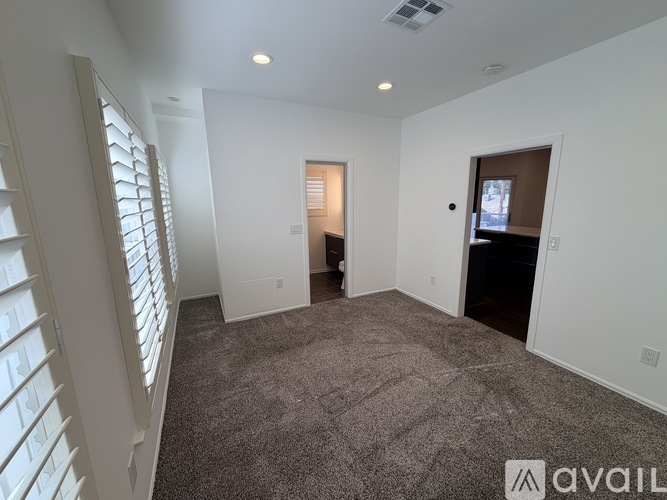 A spacious room with a carpeted floor and white walls.