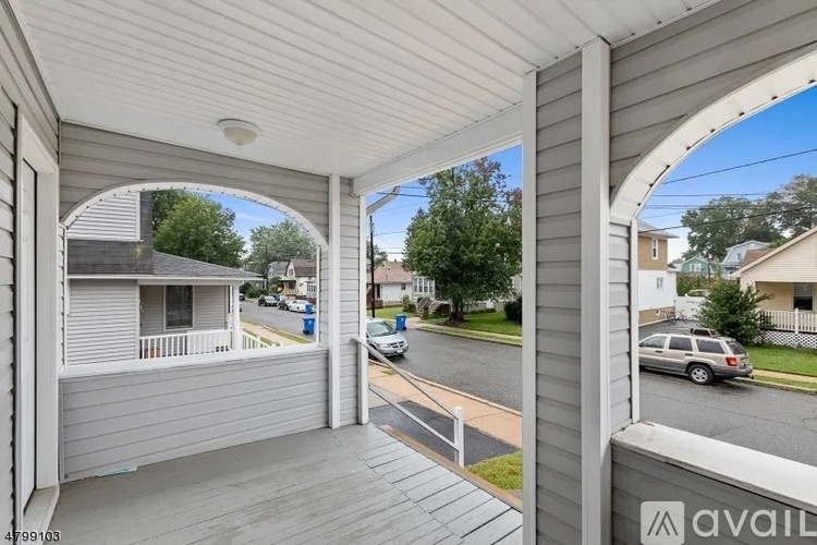 A balcony with a view of a street and houses.