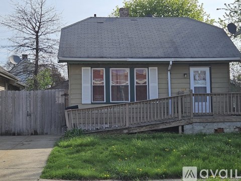 A house with a grey roof and a wooden fence.