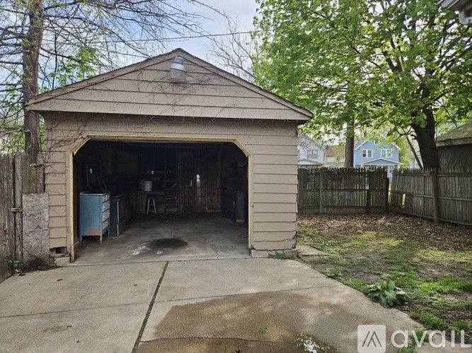 A detached garage with a concrete floor and a doorway leading to the garage.