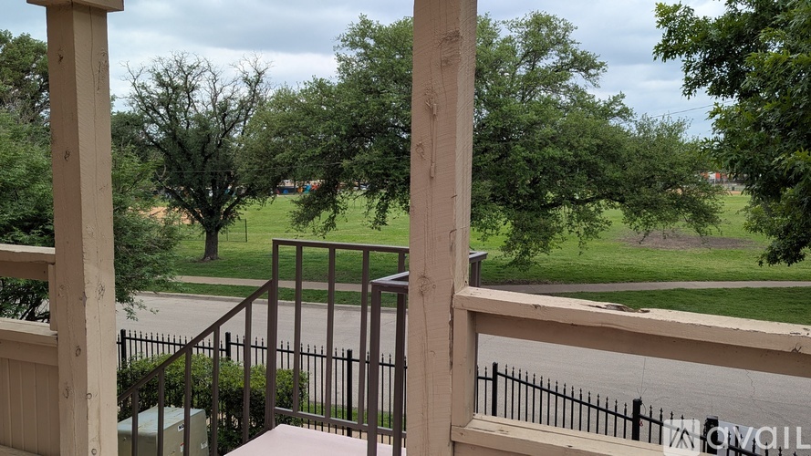 A view from a balcony looking out over a green lawn.