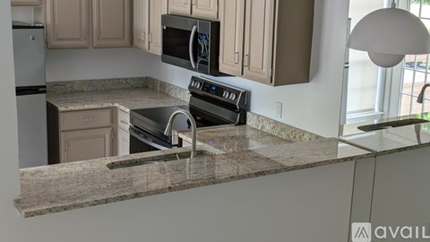 A kitchen with a granite countertop and a stainless steel oven.