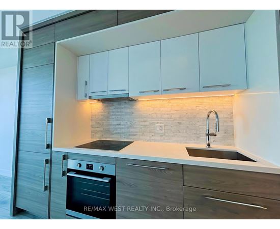A modern kitchen with a stainless steel oven and white cabinets.