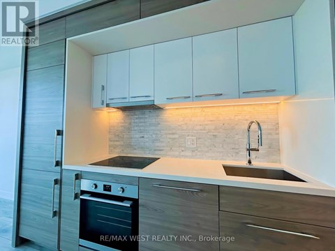 A modern kitchen with a stainless steel oven and white cabinets.