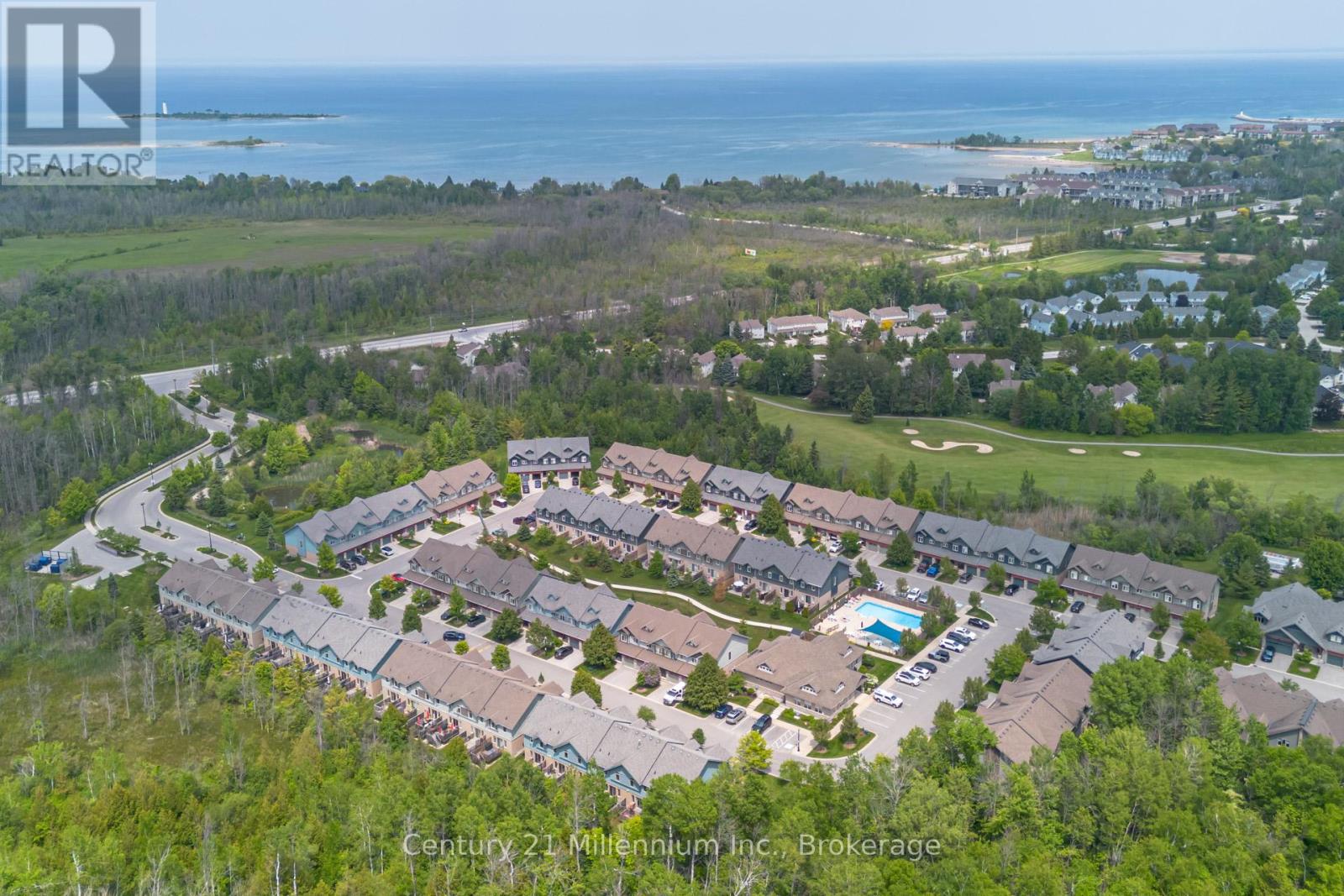 A bird's eye view of a residential area with houses and a swimming pool.