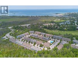 A bird's eye view of a residential area with houses and a swimming pool.