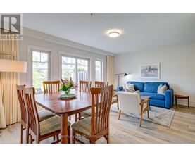 A dining room with a wooden table and chairs.