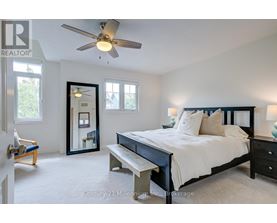 A bedroom with a bed, bench, and a fan.