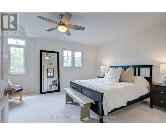 A bedroom with a bed, bench, and a fan.
