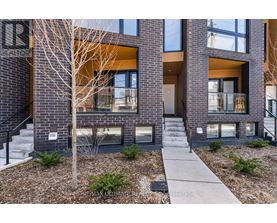 A modern brick building with a tree in front.