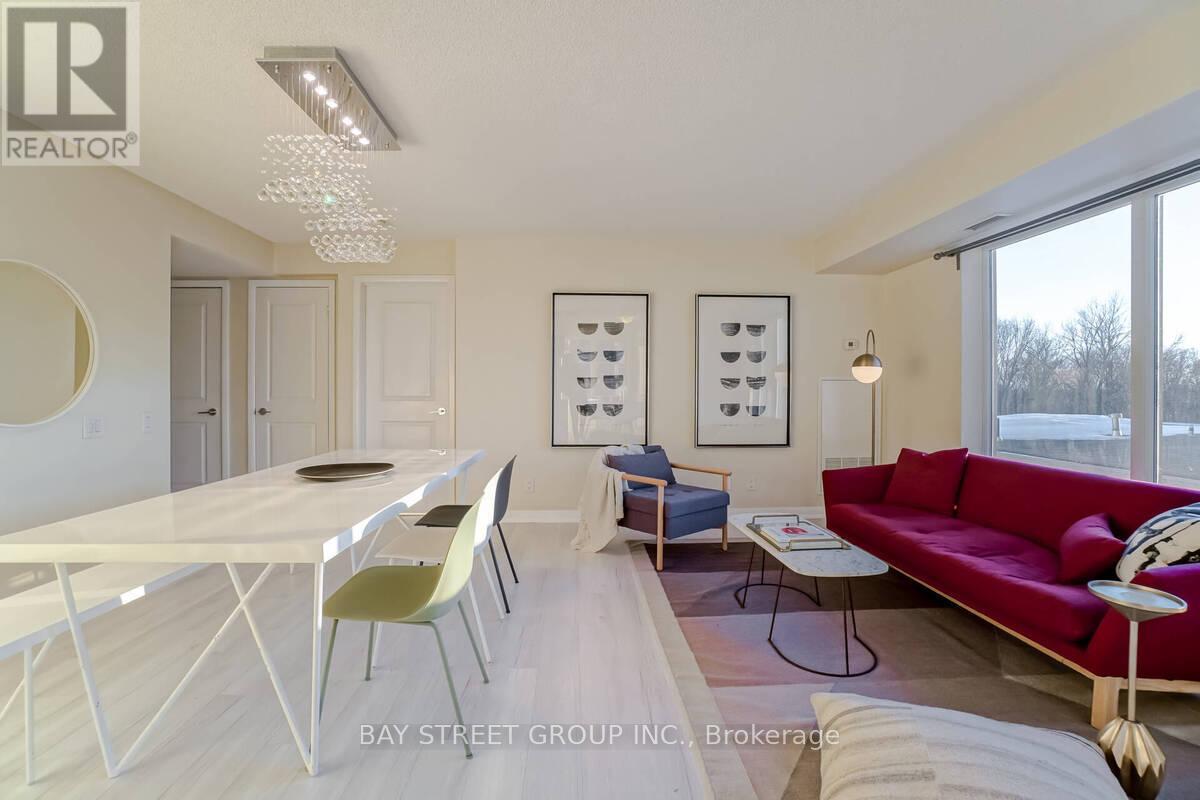 A modern dining room with a white table and chairs.