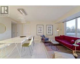A modern dining room with a white table and chairs.