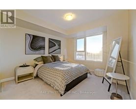 A bedroom with a bed, nightstand, and chair.
