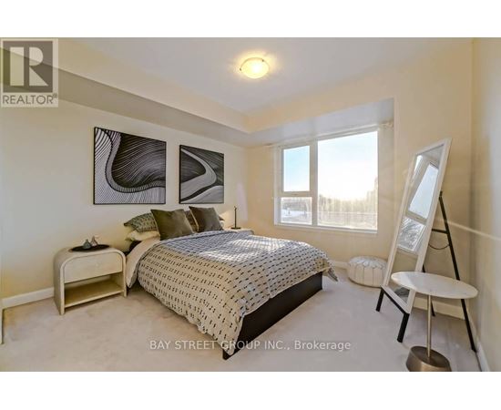 A bedroom with a bed, nightstand, and chair.