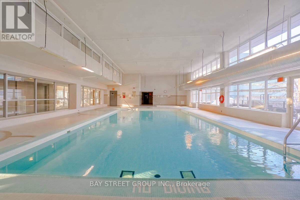 A large indoor swimming pool with the words "Bay Street Group Inc. Brokerage" written on the bottom.