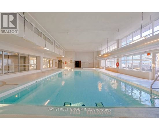 A large indoor swimming pool with the words "Bay Street Group Inc. Brokerage" written on the bottom.