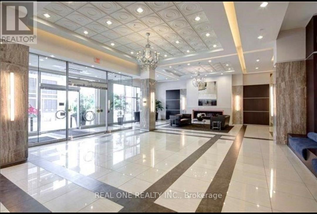 A spacious lobby with a marble floor and a chandelier.