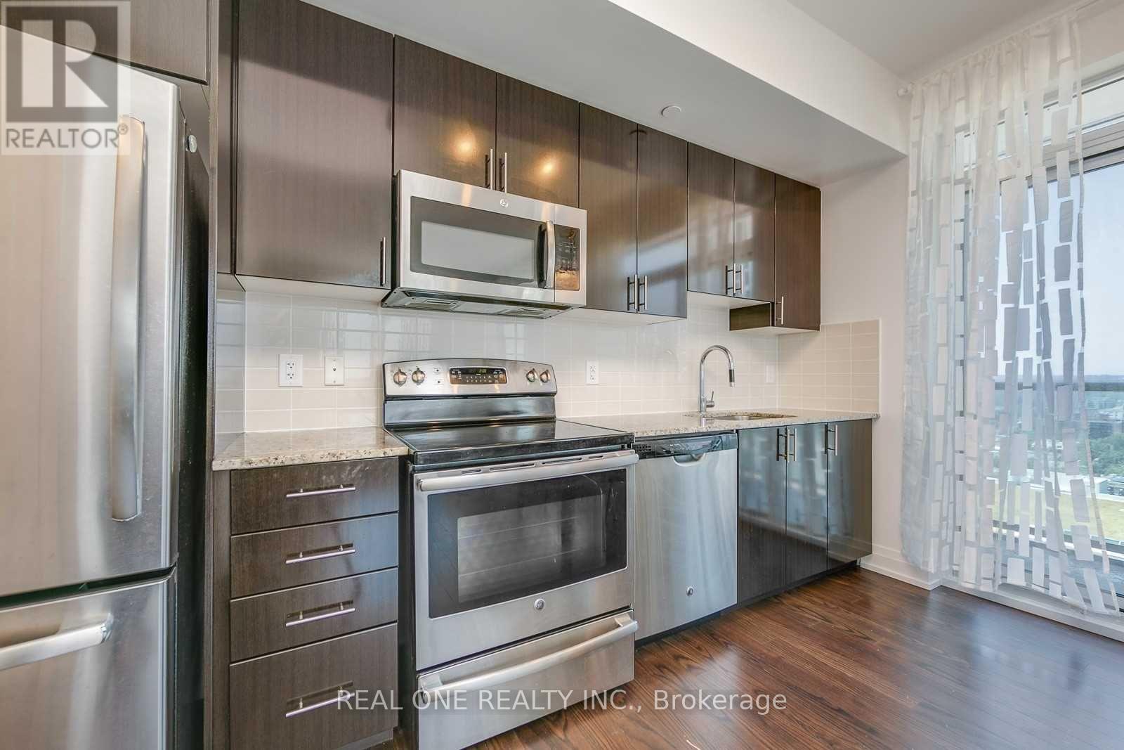 A modern kitchen with stainless steel appliances and wooden cabinets.
